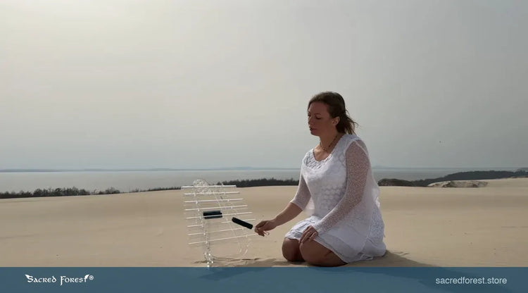 
                    
                      Natalia with Sun D Sacred Forest Crystal Harp playing with crystal mallet on the sand dunes
                    
                  