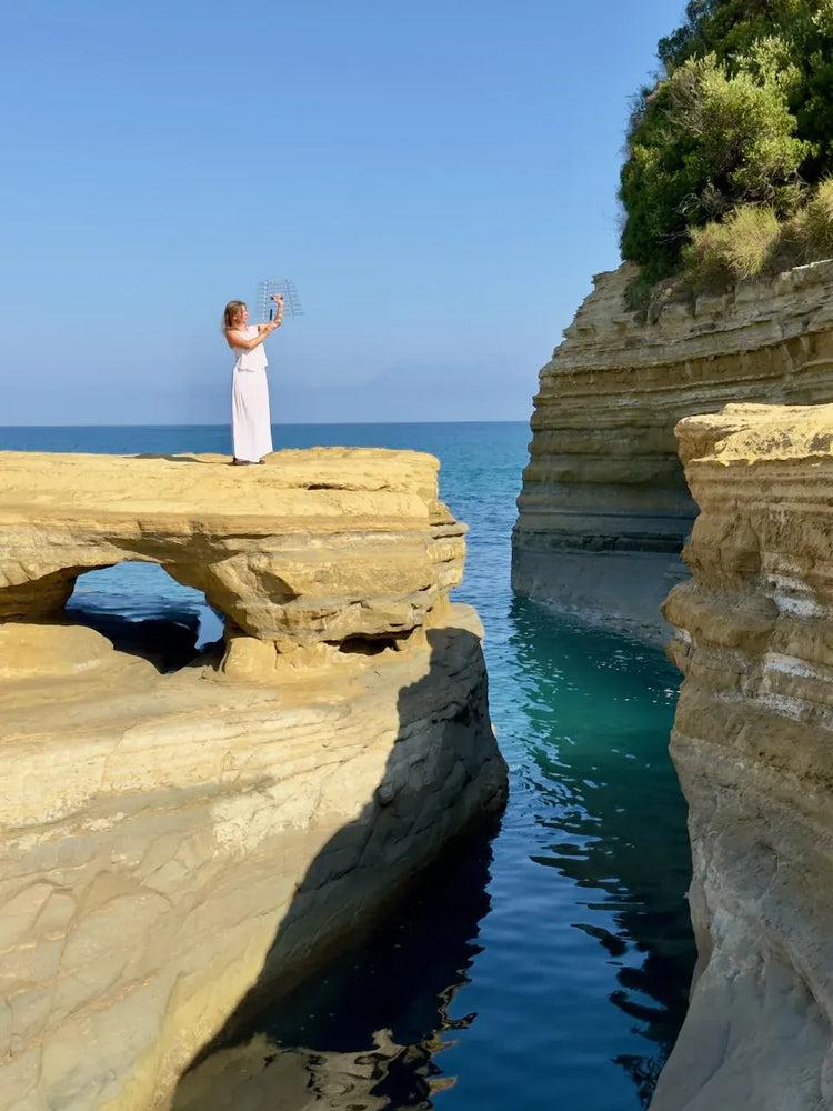 
                    
                      Natalia playing  Stardust C# Sacred Forest Crystal Harp while standing on natural rock bridge over clear turquoise water
                    
                  